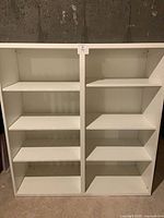 Full frontal view of the white two-bay shelving unit with six shelves