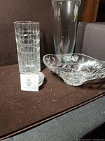 Group shot showing cylindrical cut vase, heart-shaped box, cut glass bowl, partial tall smooth vase