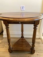 Table fully extended showing round top, turned legs, triangular stretcher