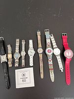 Eight watches laid out left to right on black surface