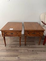 Two identical wooden end tables side by side