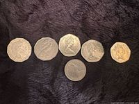 Obverse sides of six coins on black fabric