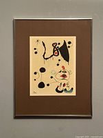 Front view of framed Joan Miró print under brown mat and silver frame