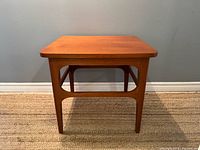 front view of square teak side table showing legs and stretcher