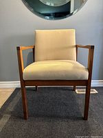 Front view of walnut armchair showing overall design and upholstery