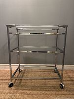 Full frontal view of bar cart showing three glass tiers and chrome/lucite frame