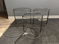 Three round steel and glass stacking side tables grouped