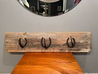 Front view showing entire coat rack and three horseshoe hooks