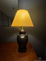 Front view of lamp illuminated showing full form and shade