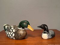 Front view of both wooden duck decoys on table