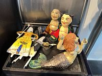 Group view of all figurines arranged in wood tray