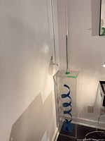 Full view of acrylic case with blue spiral sculpture and stick lamp