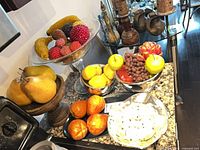 Overall countertop view showing all bowls, faux fruit and candles