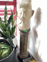 Bust on pedestal near plant