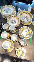 Stacked dinner plates, side plates, bowls, cups, saucers, creamer, sugar bowl, serving bowl, platter