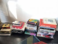 Three floor stacks of large coffee table books