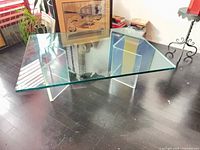 Front view of glass coffee table showing top and acrylic legs