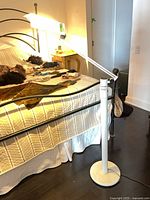 Entire lamp beside bed showing base, arm, and head