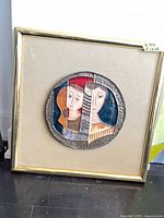 Full view of framed ceramic relief sculpture standing on floor