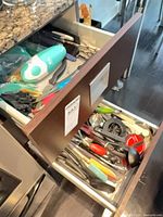 Two open kitchen drawers showing assorted utensils