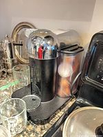 Coffee machine with four clear glass mugs, French press partly visible