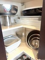 Cupboard with hammered stainless pedestal bowl, melamine bowls, glass bowls, stainless bowls, ceramic bowls