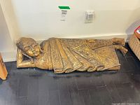 Full view of reclining goddess statue on floor