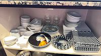 Overall view of mixed serveware and plates on shelf