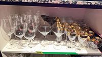 Shelf showing mixed stemware: red/white wine, martini, gold-band glasses