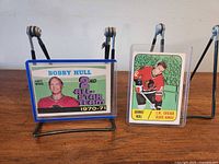 Both cards in protective holders on stands