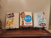 Front view of three Regal Ties cardboard signs on stands