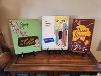 All three cardboard shoe advertising signs on display stands