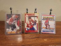 Front view of all three sleeved Eric Lindros cards on table