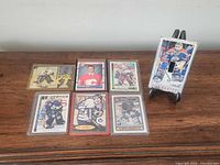 Group shot of six trading cards in sleeves and Bill Ranford switch plate