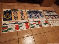 All three laminated Dominion Maple Leaf calendars laid out showing images and calendar months