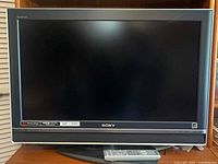 Front view of Sony Bravia HDTV on stand with remote placed below screen