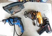 All four corded tools laid out: Bosch jigsaw, Mastercraft drill, yellow drill, Weller soldering gun