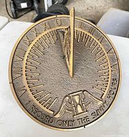 Overhead view of full brass sundial showing Roman numerals and inscription