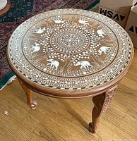 Full view of round inlaid table on hardwood floor