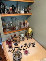 Overall view of shelves and tabletop showing majority of candleholders and candles