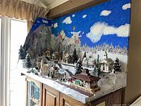 Overall view of assembled diorama on cabinet showing backdrop, village and snow base