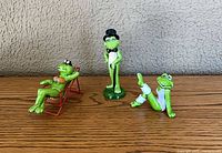 All three frog figurines on wood surface