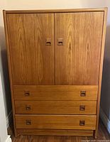 Front view of closed teak dresser-cabinet