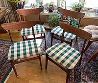 All four Danish teak dining chairs front and angled view
