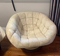 Front angled view of R. Huber clam swivel chair showing overall form and upholstery