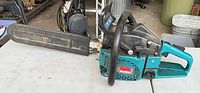Makita DCS520 gas chainsaw with bar cover on table
