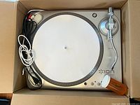 Top view of ION iTTUSB turntable in box with cables visible