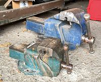 Large blue and smaller green vises side by side showing size difference and condition