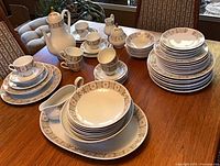 Full view of Edelstein porcelain dinner set on table showing plates, bowls, cups, saucers and serving pieces