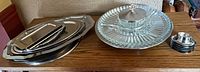 Stack of stainless trays, glass party platter, egg cups